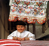 Dobre sa smeje malému Šumiačanovi na maminom vankúši. Fotografia z knihy Ľudová klenotnica Slovenska.