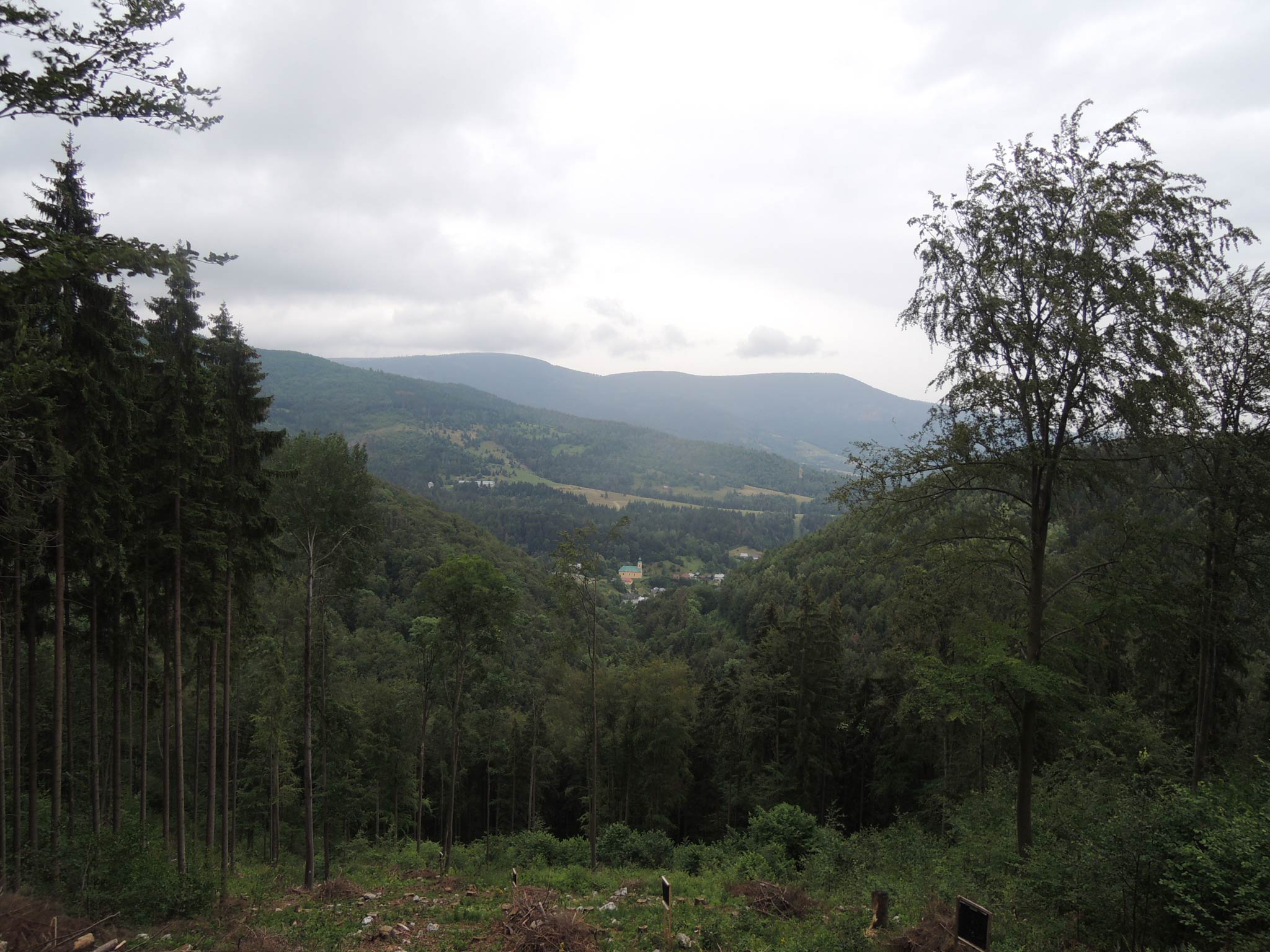 Z okraja Muránskej Planiny – Pod Skalou sa pozeráme na dedinu Muránska Huta. Nad ňou sa vypína Stolica, najvyšší vrchol Stolických vrchov (1476 m) aj celého Slovenského rudohoria